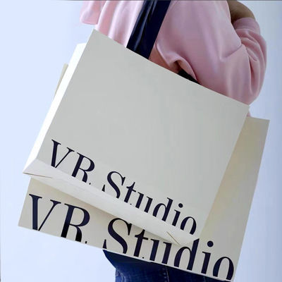 Indumenti personalizzati borse da shopping confezionamento lussuoso cartone d'avorio carta kraft a basso prezzo borsa regalo per lo shopping logo personalizzato